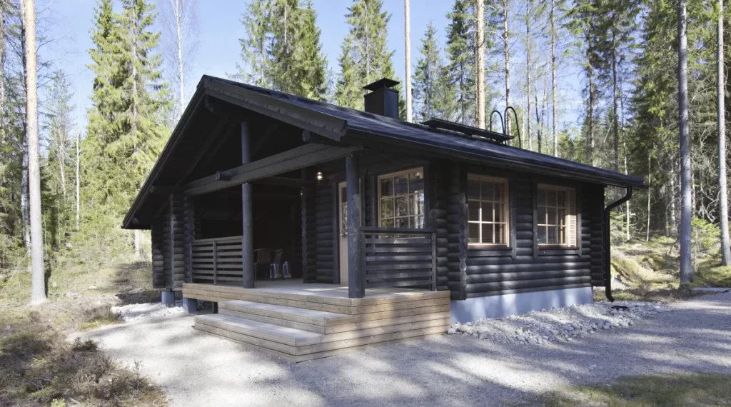 Tumma saunamökki kuistilla